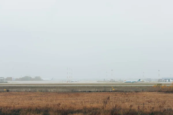 Avión en pista en campo con cielo nublado al fondo - foto de stock