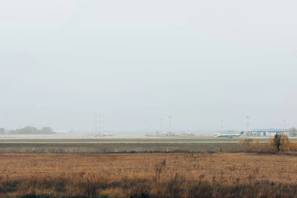 Avion sur piste dans le champ avec ciel nuageux en arrière-plan — Photo de stock