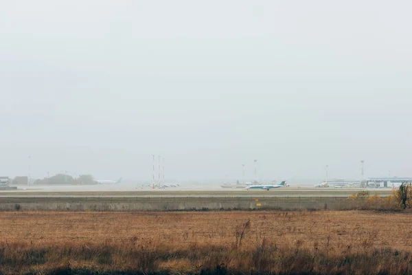 Avión en pista de aeropuerto con cielo nublado al fondo - foto de stock