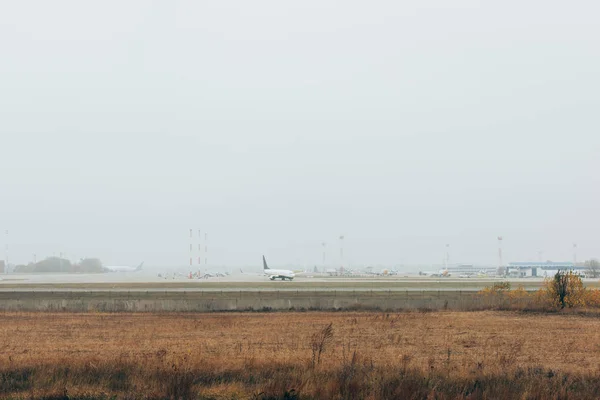 Airplanes on airport highway in grassy field — Stock Photo