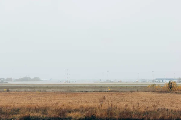 Campo de aviación cubierto de hierba con aviones comerciales en la carretera - foto de stock