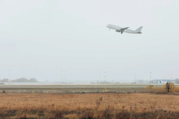 Salida del avión comercial en la pista del aeropuerto - foto de stock