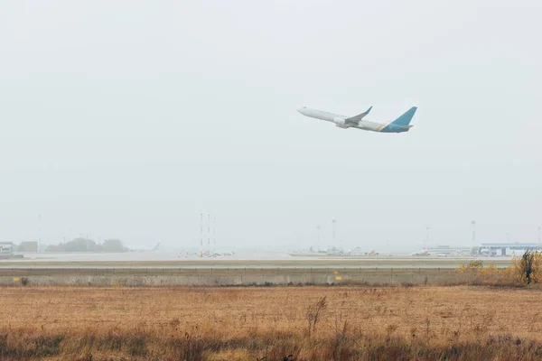 Airplane taking off from airport runway in cloudy sky — Stock Photo