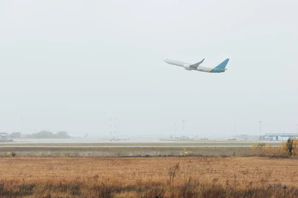 Aereo decollare dalla pista dell'aeroporto in cielo nuvoloso — Foto stock