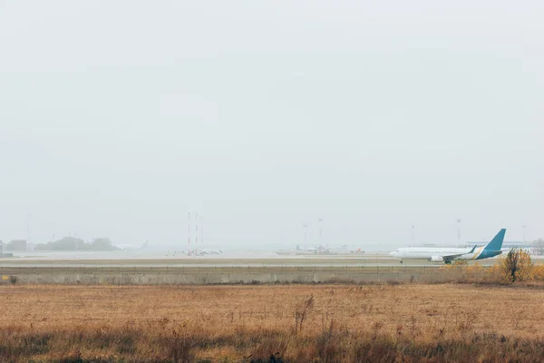 Airplane on runway with planes on airport highway — Stock Photo