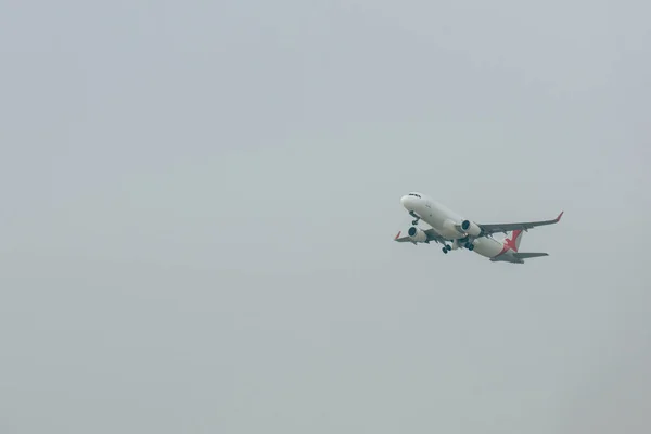 Low angle view of jet plane departure in cloudy sky — Stock Photo