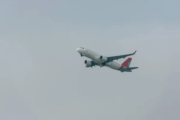 Tiefflug-Ansicht des Düsenflugzeugs bei bewölktem Himmel — Stockfoto