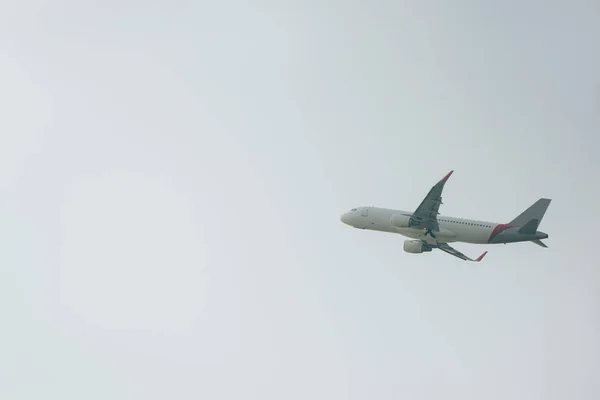 Tieffliegerblick auf Verkehrsflugzeug bei bewölktem Himmel — Stockfoto