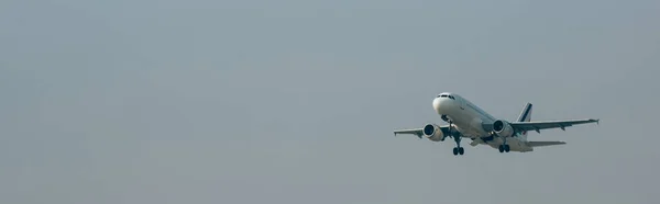 Partida de avião a jato no céu nublado, tiro panorâmico com espaço de cópia — Fotografia de Stock