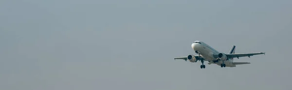 Departure of jet plane in cloudy sky, panoramic shot with copy space — Stock Photo