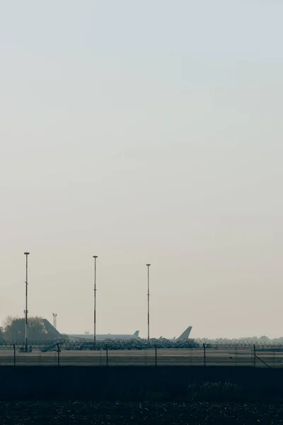 Літаки на шосе аеропорту з заходом сонця на задньому плані. — стокове фото