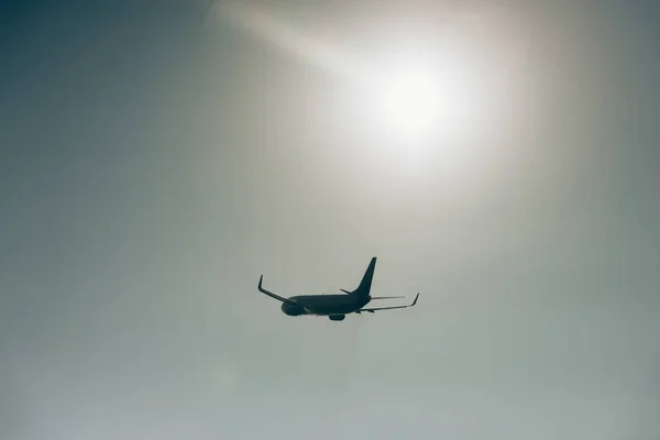 Vue à angle bas de l'avion à réaction dans le ciel avec soleil — Photo de stock