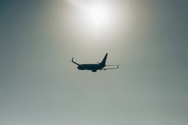 Salida de vuelo de avión comercial con sol en el cielo al fondo - foto de stock