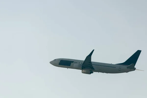 Vue en angle bas de l'avion montant dans un ciel dégagé — Photo de stock