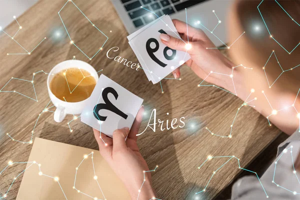 Overhead view of woman holding cards with zodiac signs near constellations — Stock Photo