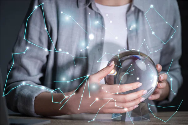 Cropped view of woman using crystal ball near constellations — Stock Photo