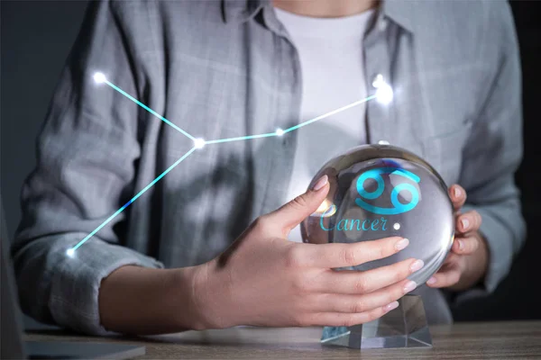 Cropped view of woman using crystal ball near cancer constellation — Stock Photo