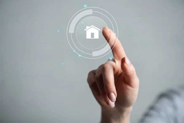 Cropped view of woman pointing with finger on house isolated on grey — Stock Photo