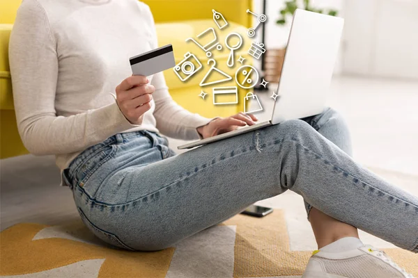 Vista ritagliata di giovane donna in possesso di carta di credito e utilizzando laptop vicino illustrazione — Foto stock