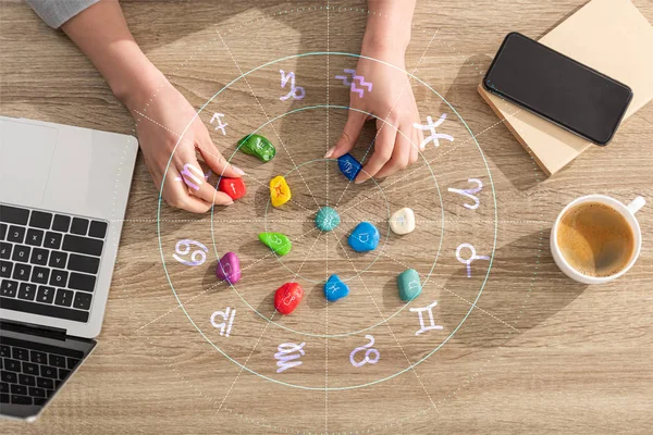 Top view of astrologer holding stones with zodiac sign beside laptop, coffee illustration — Stock Photo