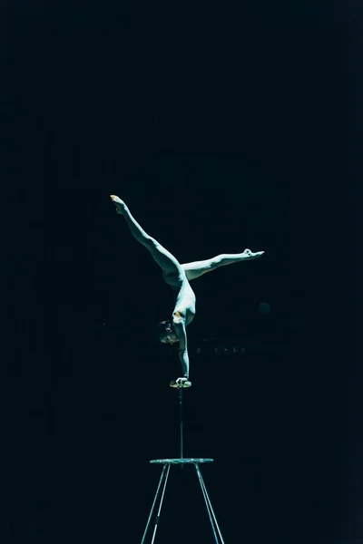 KYIV, UKRAINE - NOVEMBER 1, 2019: Gymnast performing handstand in circus isolated on black — Stock Photo