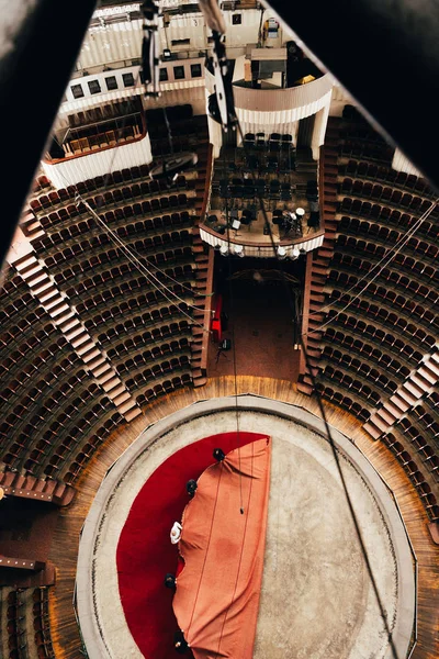 Vista superior de los hombres que ponen la cubierta roja en la arena del circo - foto de stock