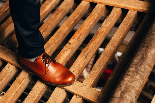 Ausgeschnittene Ansicht eines Mannes in braunem Schuh, der auf Holzplanken steht — Stockfoto