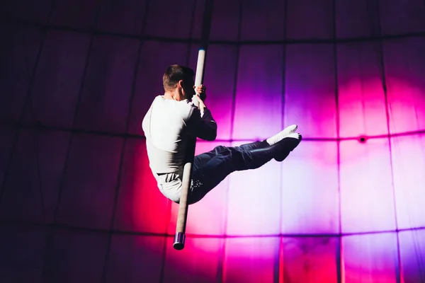 KYIV, UCRANIA - 1 DE NOVIEMBRE DE 2019: Vista lateral de gimnasta de aire actuando con poste en circo - foto de stock