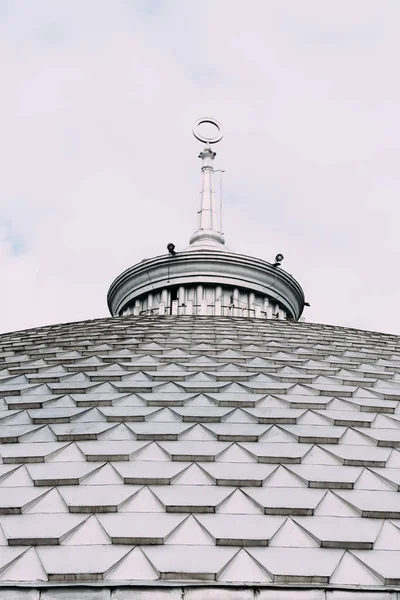 Visão de ângulo baixo de torre no telhado do edifício com céu nublado no fundo — Fotografia de Stock