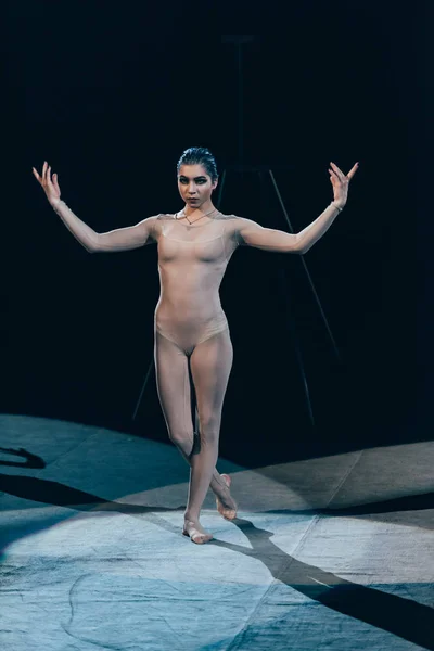 KYIV, UKRAINE - NOVEMBER 1, 2019: Attractive gymnast with raised hands standing at circus arena — Stock Photo