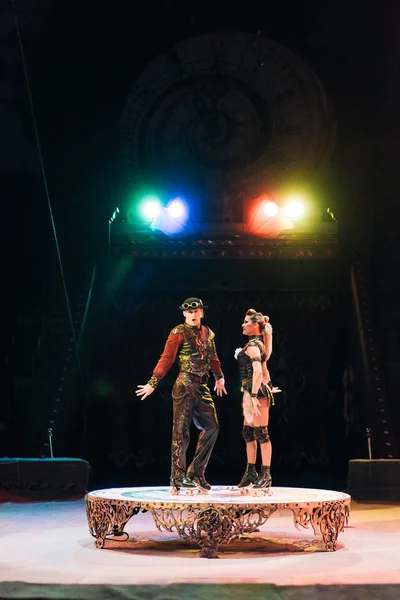 KYIV, UCRANIA - 1 DE NOVIEMBRE DE 2019: Acróbatas sobre patines que actúan en circo con reflectores al fondo - foto de stock