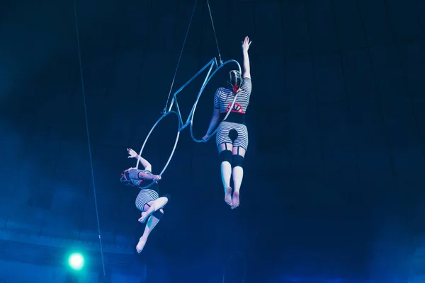 KYIV, UKRAINE - 1er NOVEMBRE 2019 : Vue en angle bas des gymnastes qui jouent avec des anneaux métalliques au cirque — Photo de stock