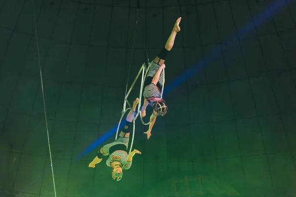 KYIV, UKRAINE - NOVEMBER 1, 2019: Low angle view of flexible air gymnasts doing split while performing with rings in circus — Stock Photo