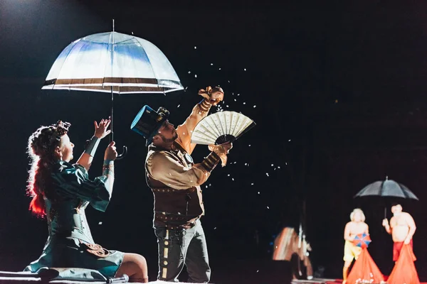 КИЕВ, УКРАИНА - 1 НОЯБРЯ 2019: Выборочный фокус артистов, выступающих с зонтиком, фанатами и конфетти в цирке — стоковое фото