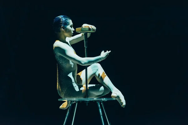 КИЕВ, УКРАИНА - 1 НОЯБРЯ 2019 г.: Прекрасная гимнастка, выступающая с оборудованием в цирке, изолированном от черного — стоковое фото