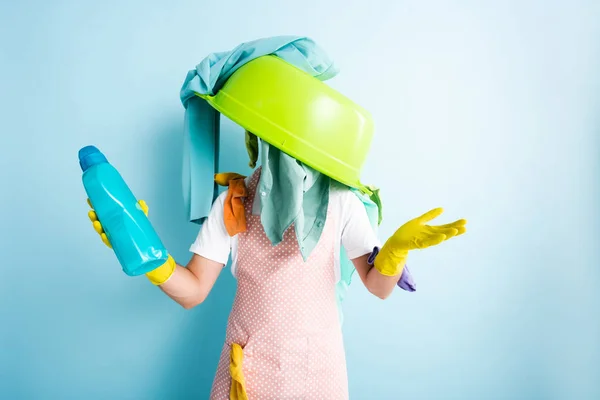 Plastic wash bowl and dirty laundry on man holding laundry detergent — Stock Photo