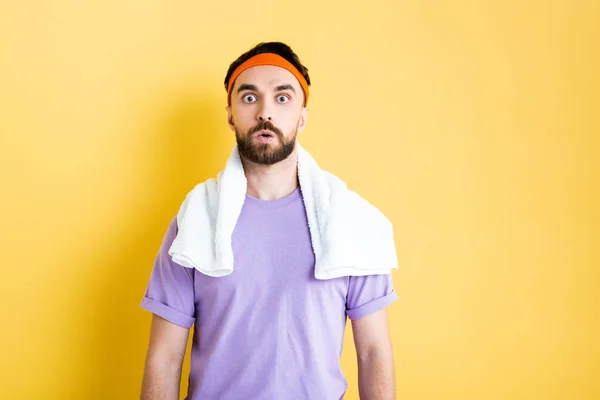 Shocked bearded sportsman looking at camera on yellow — Stock Photo