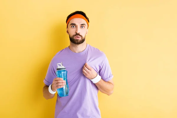 Desportista cansado segurando garrafa de esportes em amarelo — Fotografia de Stock