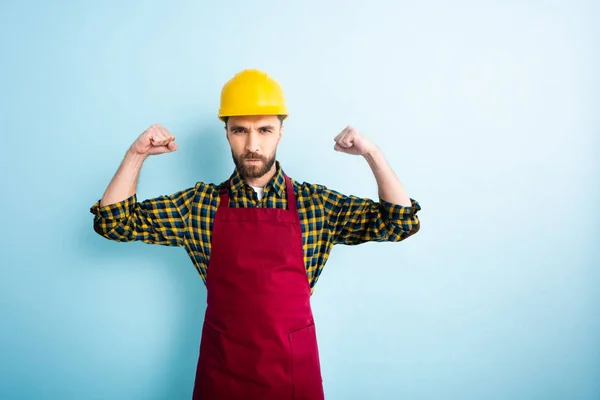 Arrabbiato uomo barbuto in piedi con pugni serrati sul blu — Foto stock