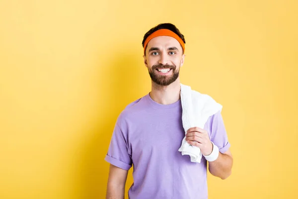 Alegre barbudo deportista sosteniendo la toalla en amarillo - foto de stock