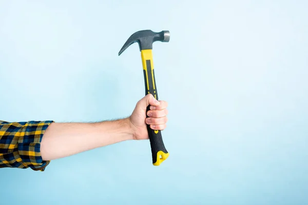 Cropped view of workman holding hammer isolated on blue — Stock Photo