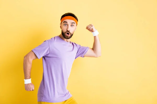 Scioccato uomo barbuto in esecuzione su giallo — Foto stock