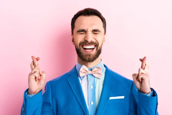 Hombre barbudo en traje con los dedos cruzados en rosa - foto de stock