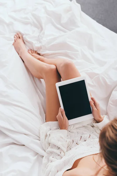 Vista ritagliata della donna utilizzando tablet digitale con schermo bianco sul letto — Foto stock