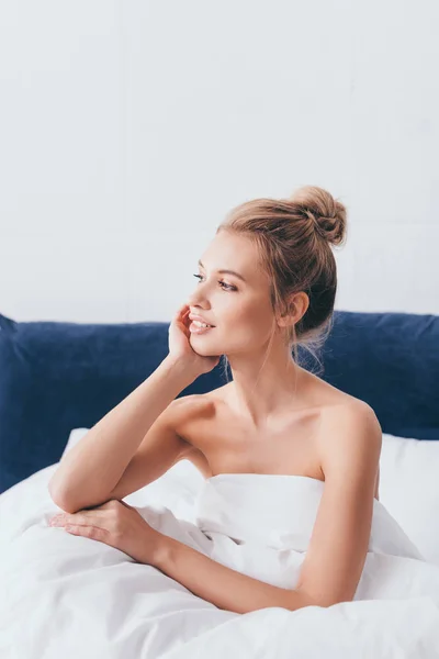 Bella donna positiva seduta a letto al mattino — Foto stock