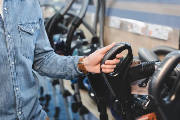 Cropped view of man holding handle of vacuum cleaner in home appliance store — Stock Photo