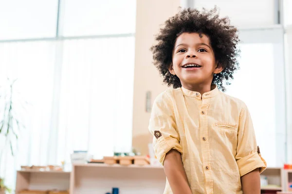 Vue en angle bas de l'enfant afro-américain souriant tout en détournant le regard — Photo de stock