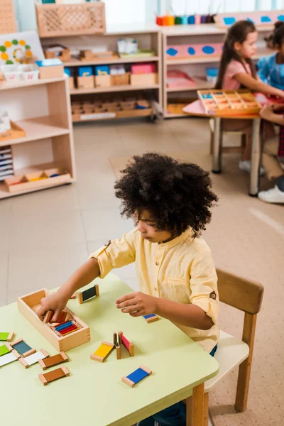 Concentration sélective du jeu d'enfant avec les enfants en arrière-plan à l'école montessori — Photo de stock