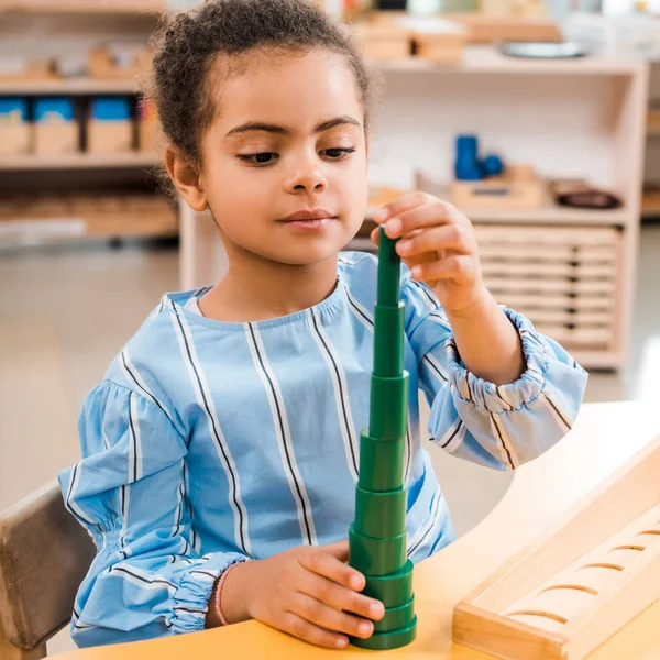 Enfant afro-américain jouant au jeu pendant les cours à l'école montessori — Photo de stock