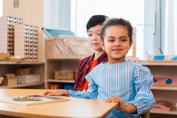 Kids with wooden game on table in montessori school — Stock Photo